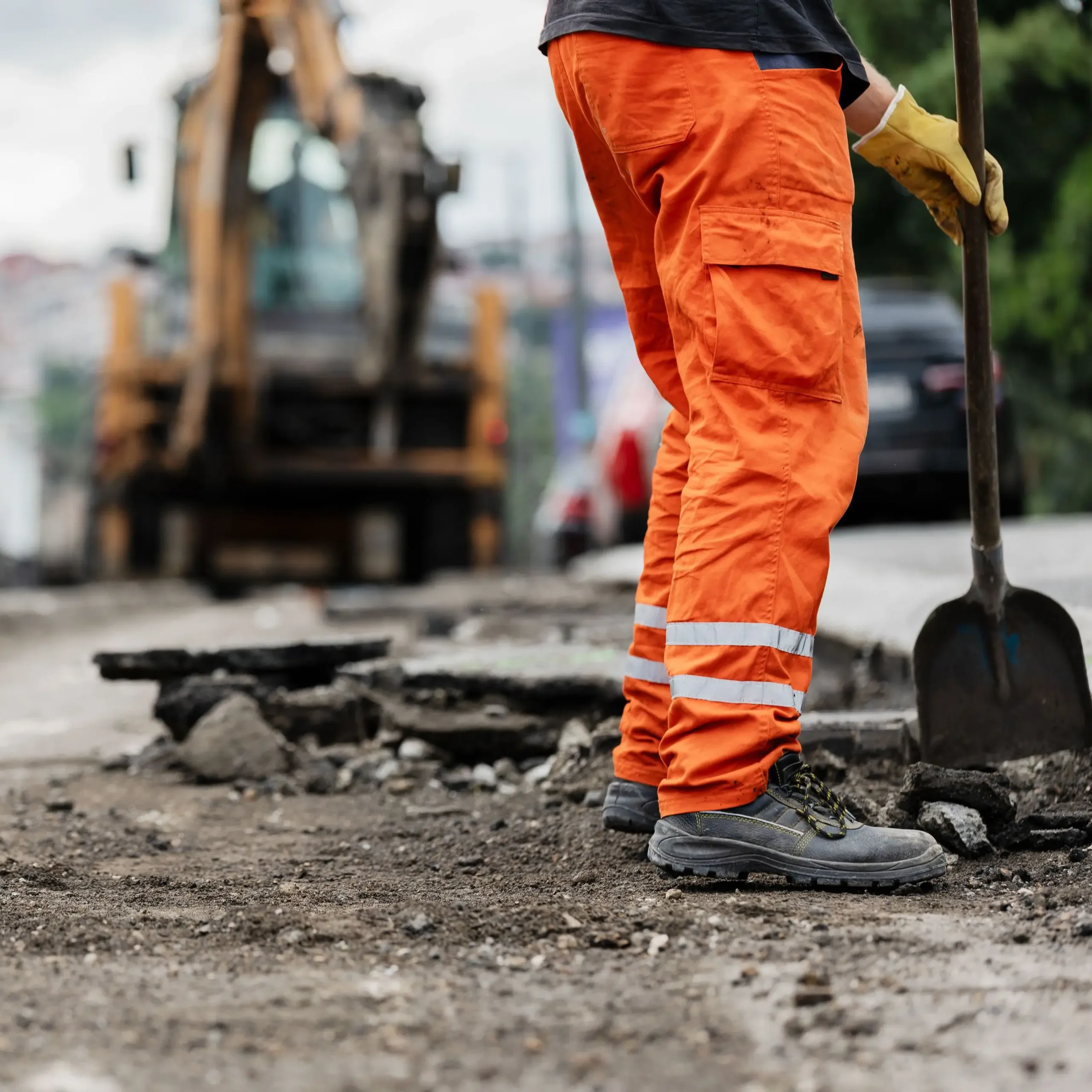 Construction worker repairs road surface
