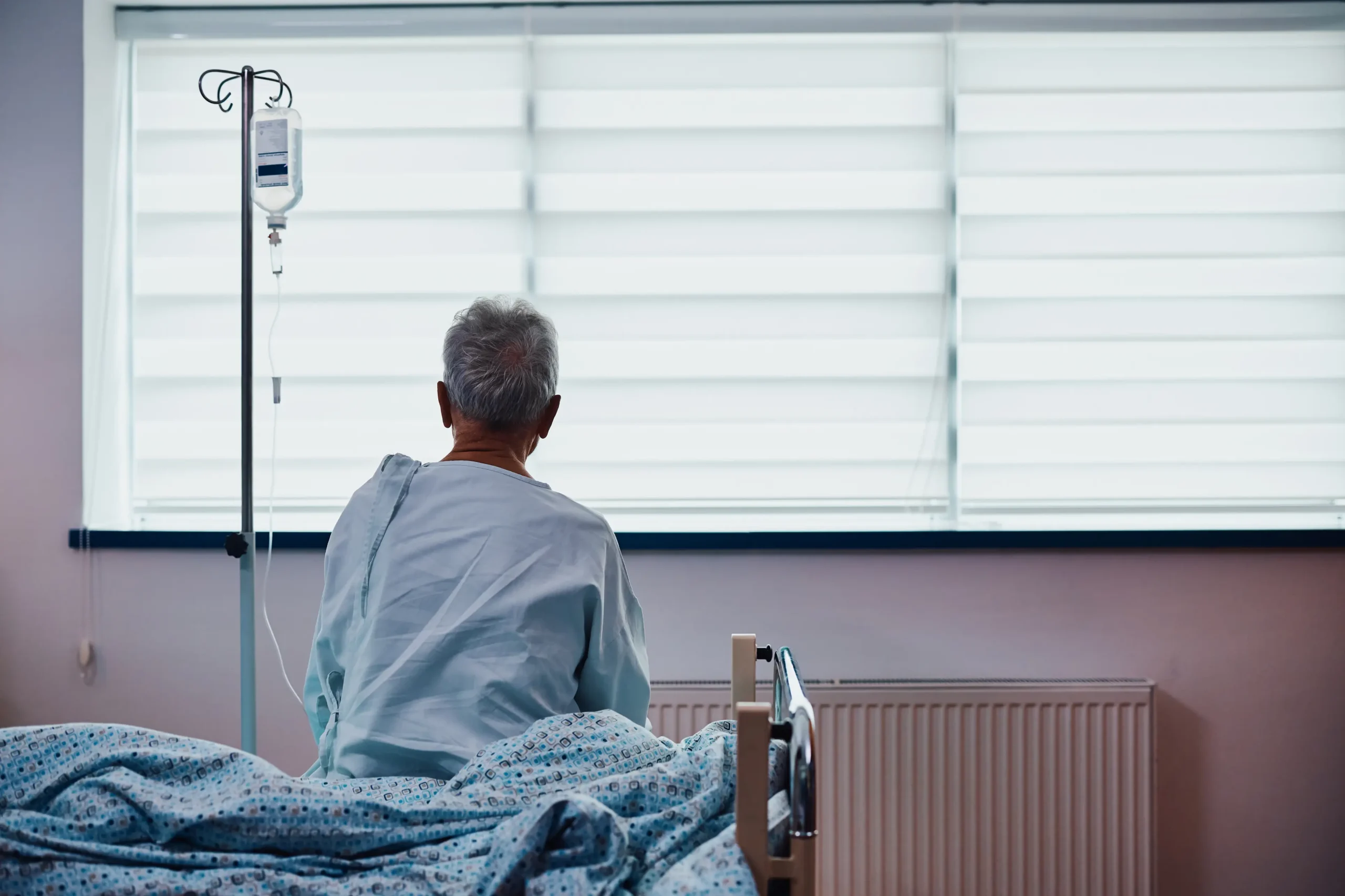 Rear view of senior hospitalized man with IV drip. stock photo