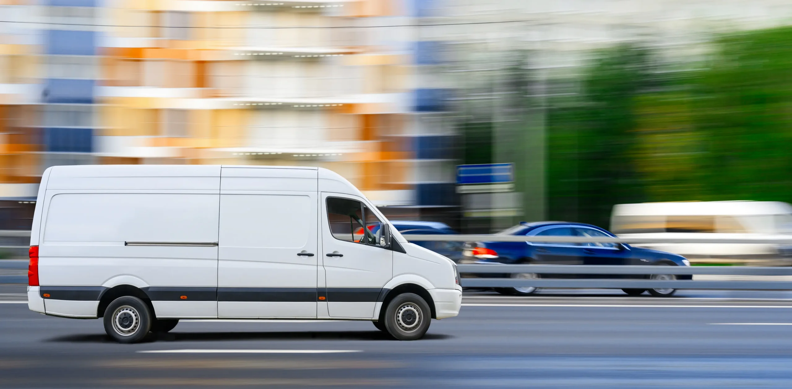 White van drives on city traffic