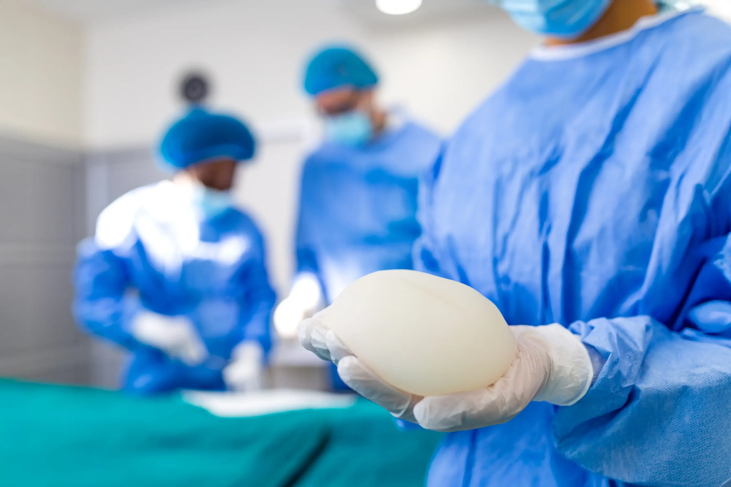 Surgeon holding silicone breast implant